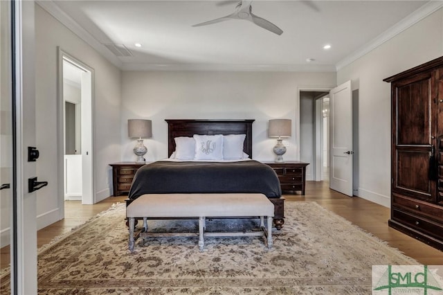 bedroom with baseboards, visible vents, wood finished floors, and ornamental molding