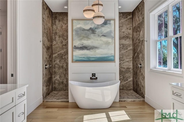 bathroom featuring a freestanding bath, wood finished floors, and walk in shower