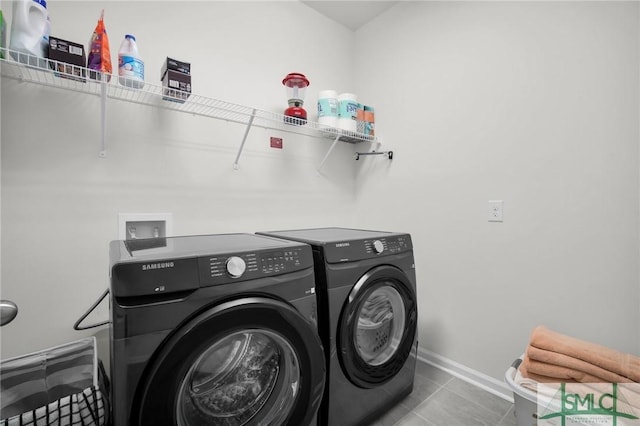 laundry area with washing machine and dryer, laundry area, baseboards, and tile patterned floors