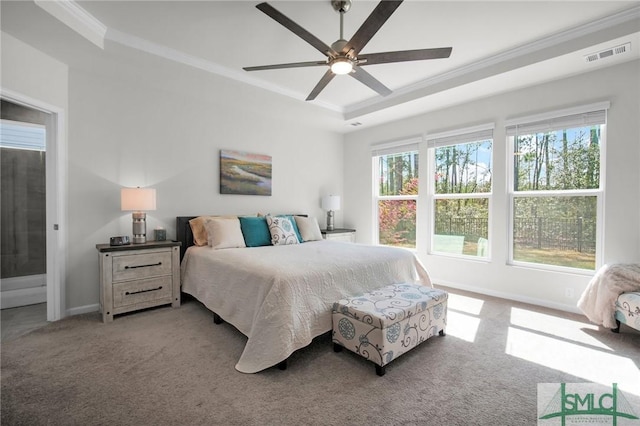 bedroom with a tray ceiling, visible vents, ornamental molding, carpet flooring, and baseboards