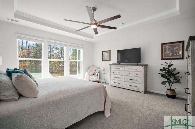 bedroom with baseboards, visible vents, a raised ceiling, and light colored carpet