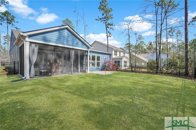 rear view of house featuring a lawn, fence, and a sunroom