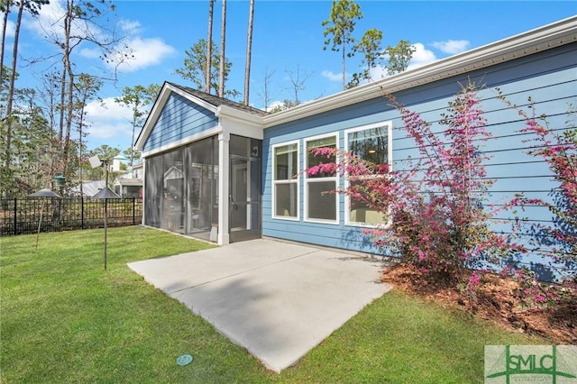 rear view of property with a sunroom, fence, a lawn, and a patio