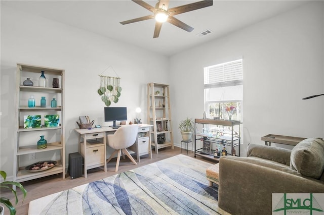 home office featuring ceiling fan, wood finished floors, and visible vents