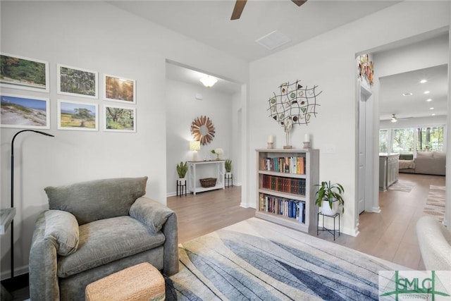 sitting room with ceiling fan, baseboards, wood finished floors, and recessed lighting