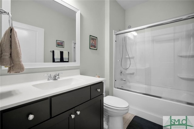 full bath with toilet, shower / bath combination with glass door, and vanity