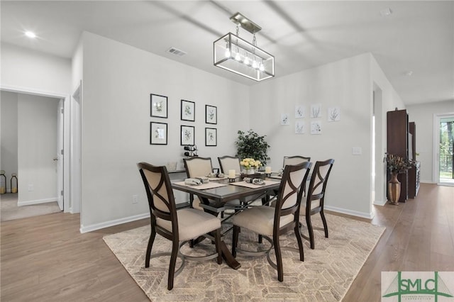 dining room featuring wood finished floors, visible vents, and baseboards