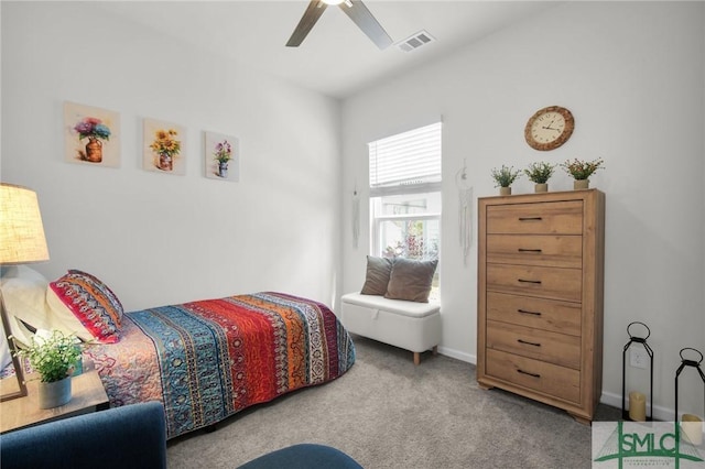 carpeted bedroom featuring a ceiling fan, visible vents, and baseboards