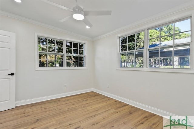 unfurnished room with crown molding, light wood finished floors, and baseboards