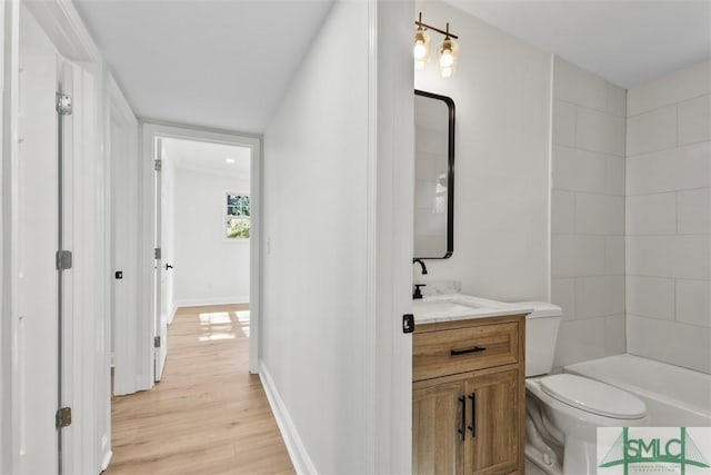 bathroom featuring vanity, wood finished floors, toilet, and baseboards