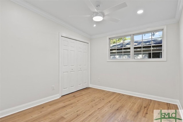 unfurnished bedroom with ornamental molding, light wood-type flooring, a closet, and baseboards