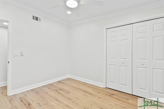 unfurnished bedroom featuring light wood-style floors, baseboards, visible vents, and crown molding