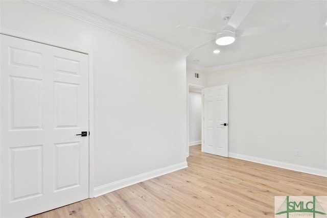 interior space with ornamental molding, a ceiling fan, light wood-style flooring, and baseboards