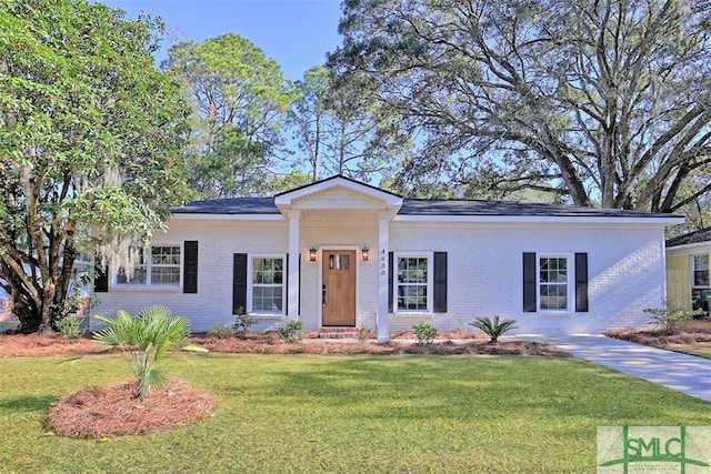 ranch-style home featuring a front lawn and brick siding