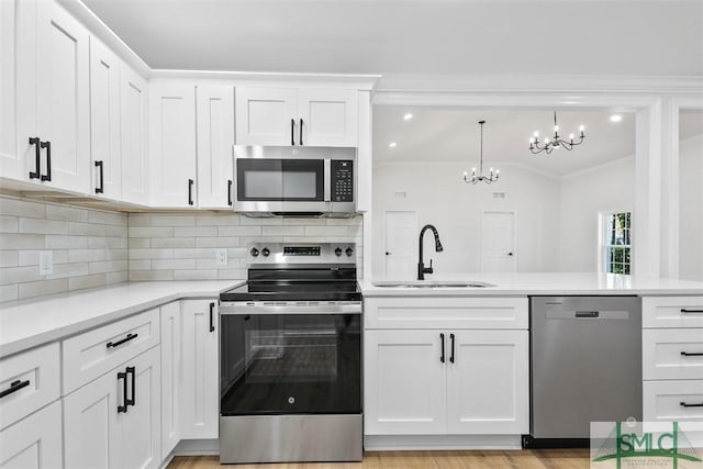 kitchen with white cabinetry, stainless steel appliances, a sink, and light countertops