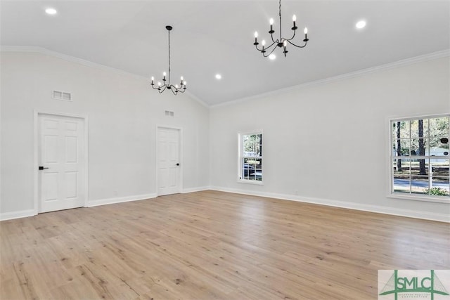 unfurnished dining area with crown molding, a healthy amount of sunlight, light wood finished floors, and an inviting chandelier