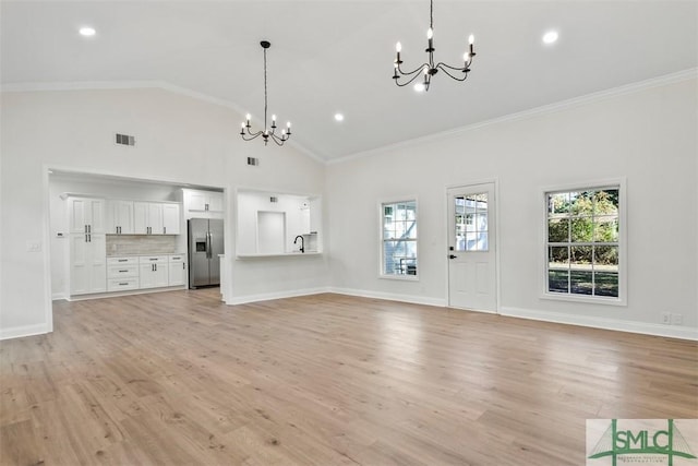 unfurnished living room with a chandelier, visible vents, baseboards, light wood-style floors, and ornamental molding