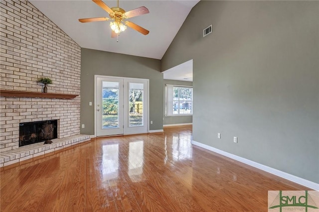 unfurnished living room featuring visible vents, a fireplace, baseboards, and wood finished floors