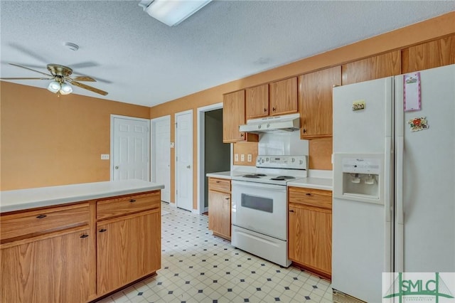 kitchen featuring a textured ceiling, under cabinet range hood, white appliances, light countertops, and light floors