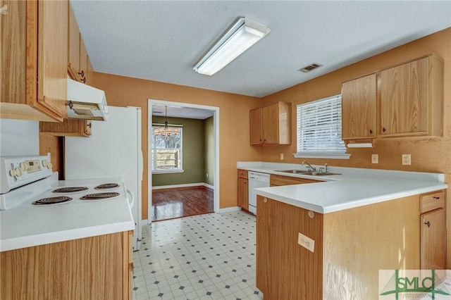 kitchen with white appliances, visible vents, a peninsula, light floors, and a sink