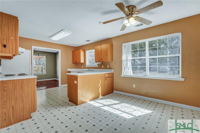 kitchen featuring light floors, freestanding refrigerator, a peninsula, and visible vents