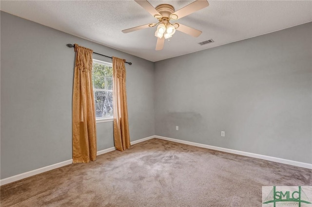 spare room featuring carpet, visible vents, ceiling fan, and baseboards