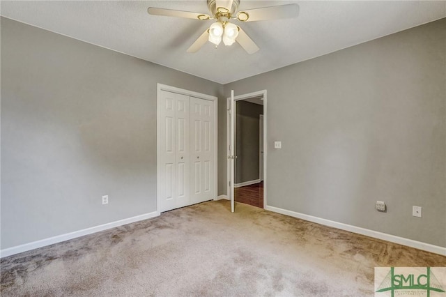 unfurnished bedroom featuring carpet floors, ceiling fan, baseboards, and a closet