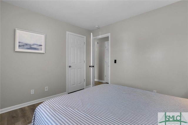 bedroom with dark wood-style floors and baseboards