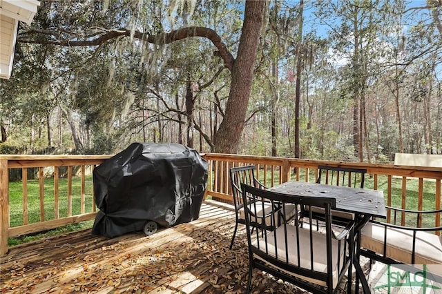 wooden terrace with a grill and outdoor dining area