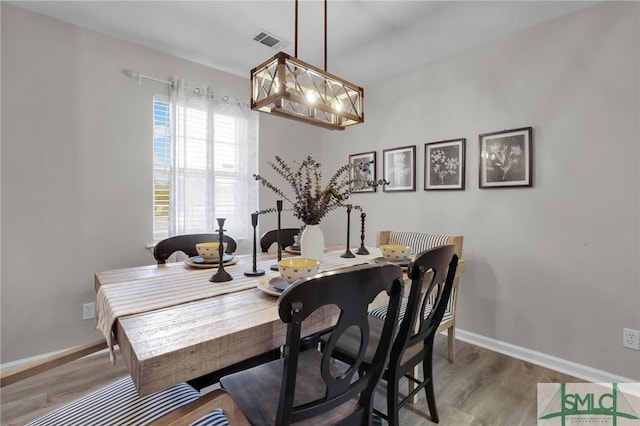 dining space featuring visible vents, baseboards, and wood finished floors