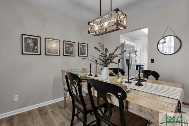 dining space with baseboards and wood finished floors