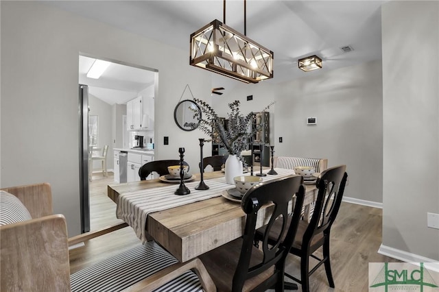 dining room with visible vents, light wood-style flooring, and baseboards