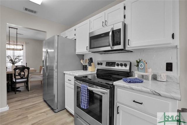 kitchen featuring tasteful backsplash, visible vents, appliances with stainless steel finishes, light wood-style floors, and white cabinets