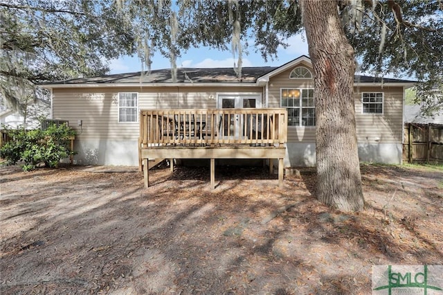 rear view of property featuring fence and a deck