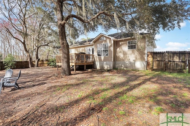 rear view of house featuring a deck and a fenced backyard