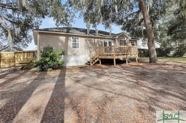 rear view of property with a deck and fence