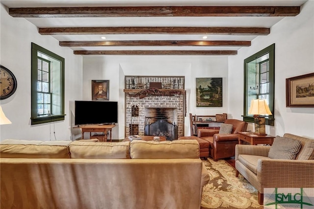 living area with a brick fireplace and beam ceiling