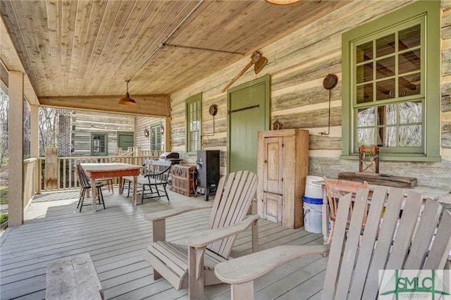 wooden deck featuring covered porch and outdoor dining area