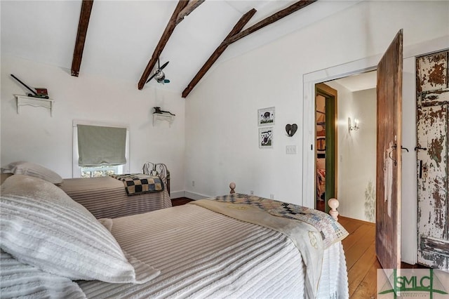 bedroom featuring lofted ceiling with beams and light wood finished floors