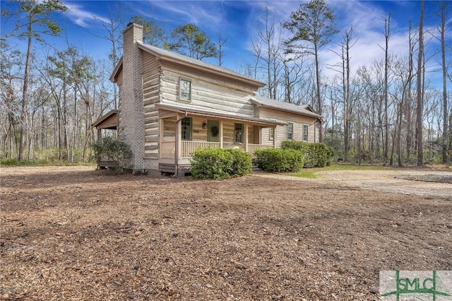 view of front of house with covered porch and a chimney