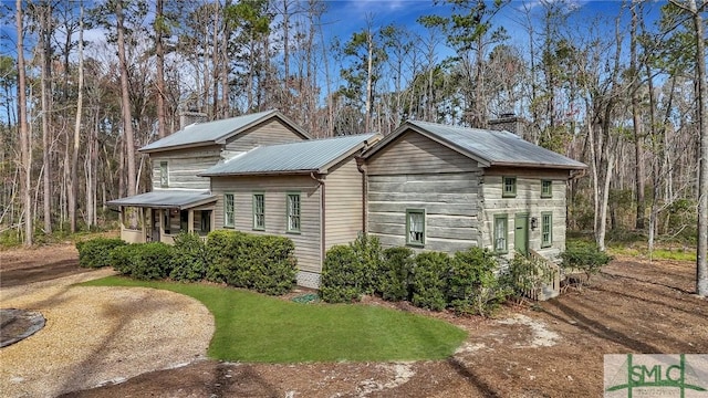 view of home's exterior featuring metal roof and a chimney