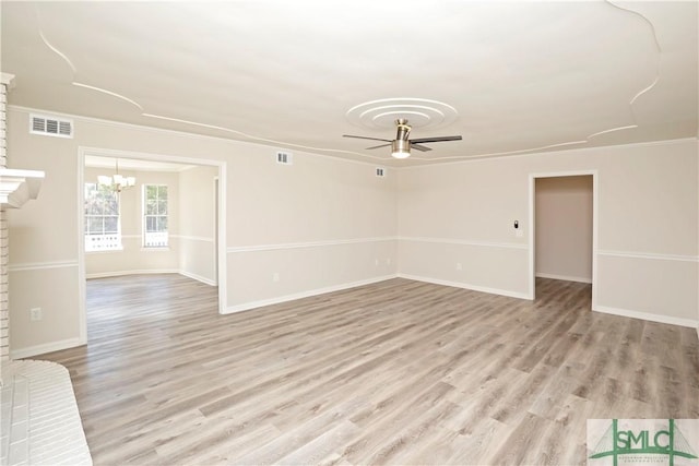 unfurnished living room featuring light wood finished floors, visible vents, ornamental molding, and ceiling fan with notable chandelier