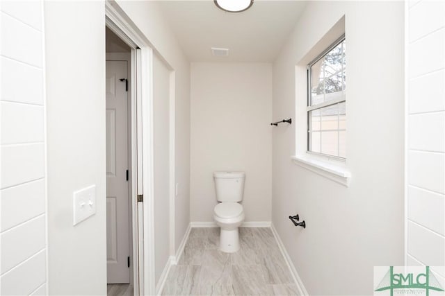 bathroom with toilet, visible vents, and baseboards