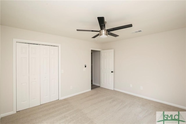 unfurnished bedroom with baseboards, visible vents, a closet, and light colored carpet