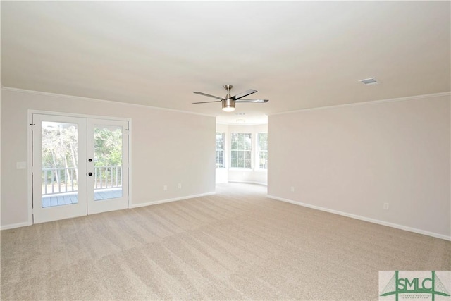 spare room featuring french doors, crown molding, light carpet, ceiling fan, and baseboards