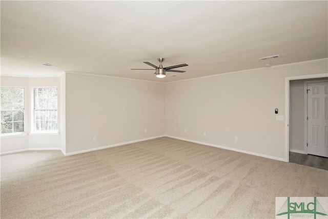 empty room featuring a ceiling fan, baseboards, visible vents, and crown molding