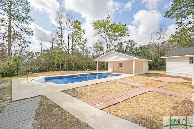 outdoor pool featuring an outbuilding and a patio area