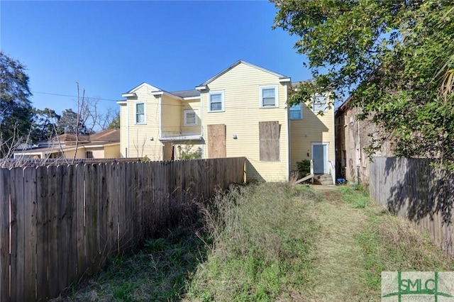 rear view of property featuring a fenced backyard