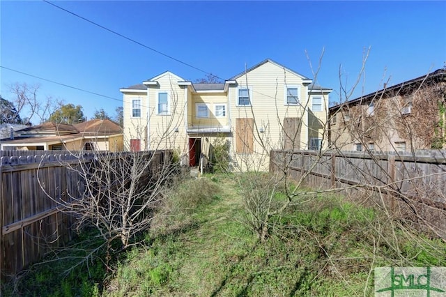 rear view of property with a fenced backyard