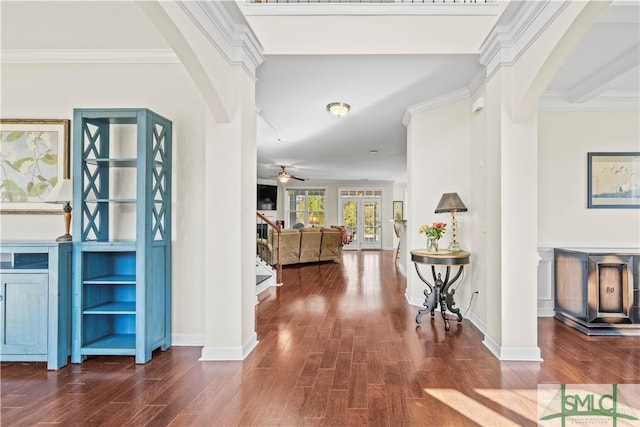 hall with stairs, arched walkways, crown molding, and wood finished floors